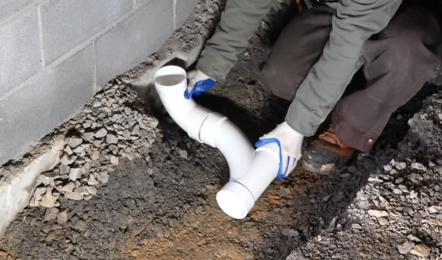 New PVC sewer fittings laid in a gravel trench before backfill