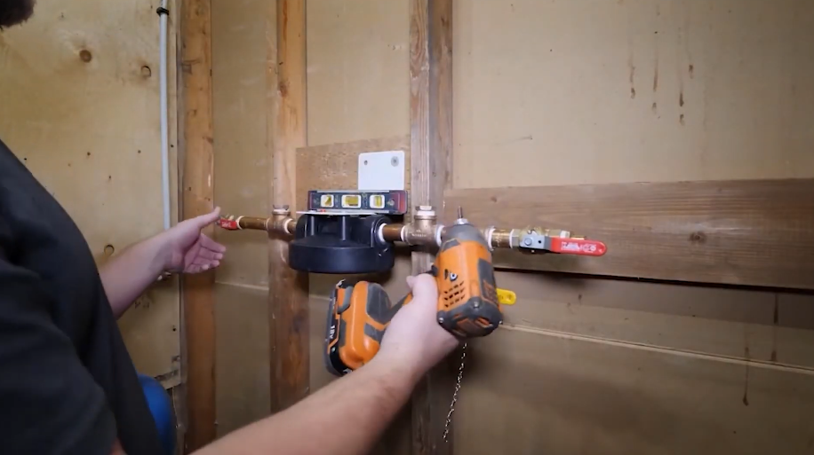 Drilling to mount a copper distribution manifold on a framed wall