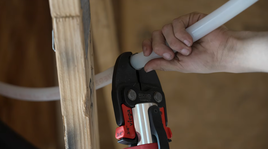 Pushing a length of white supply pipe into a push-fit connector