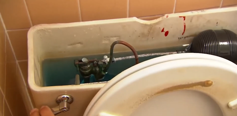 Inside a toilet tank showing the fill valve and flush assembly