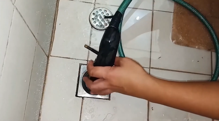 Reaching into a wall access panel to inspect concealed pipework