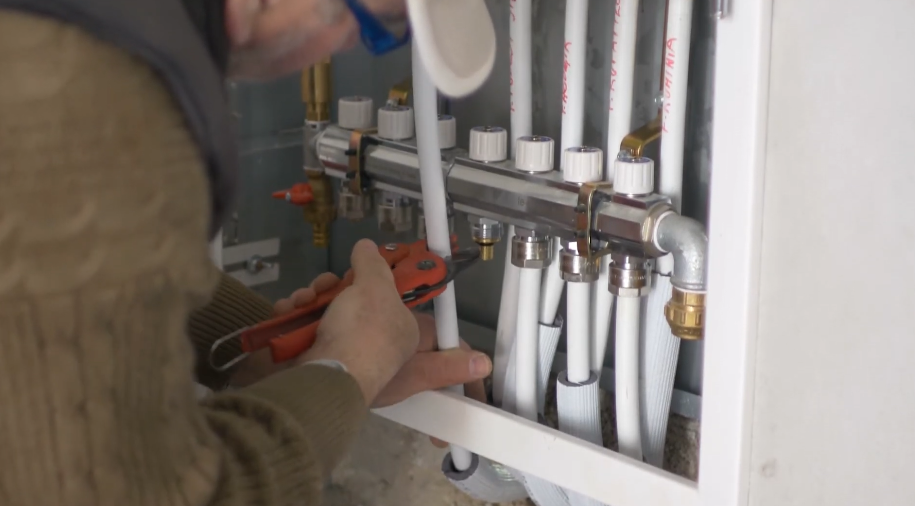 Wall mounted manifold distributing white supply lines to branch runs